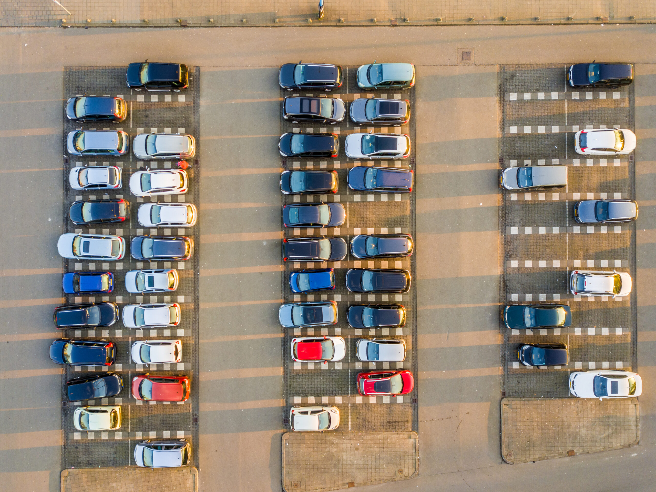 Letecký pohľad na parkovisko s radmi zaparkovaných osobných automobilov
